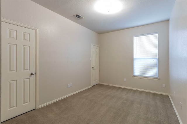 carpeted spare room with a textured ceiling