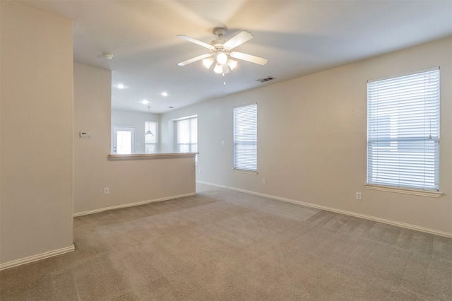 unfurnished room featuring light colored carpet and ceiling fan