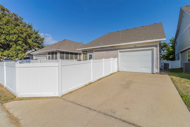 view of side of property with a garage and central AC