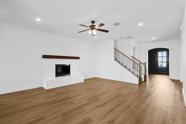 unfurnished living room featuring a fireplace, ceiling fan, and hardwood / wood-style floors