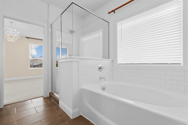 bathroom with tile patterned floors, a chandelier, and independent shower and bath