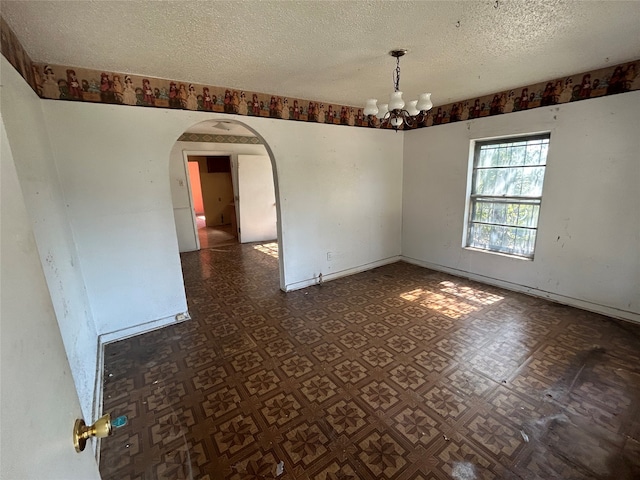 unfurnished room with an inviting chandelier and a textured ceiling