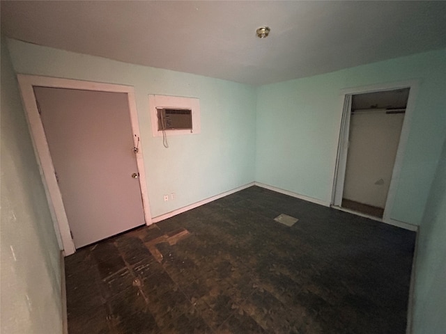 unfurnished room featuring an AC wall unit