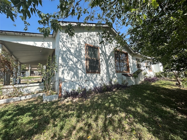 view of side of home with a lawn