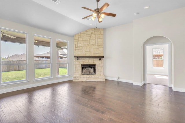 unfurnished living room with ceiling fan, a stone fireplace, dark hardwood / wood-style flooring, and vaulted ceiling