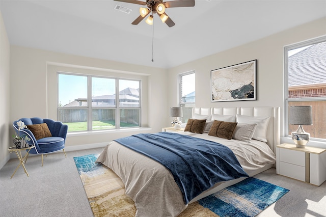 carpeted bedroom featuring multiple windows and ceiling fan