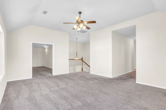 carpeted spare room featuring lofted ceiling and ceiling fan