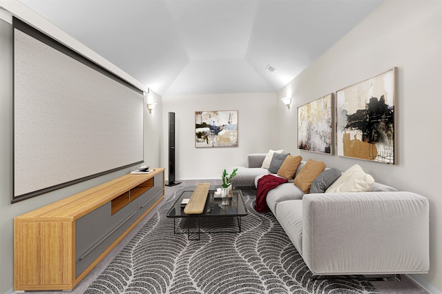 cinema room featuring dark colored carpet and lofted ceiling