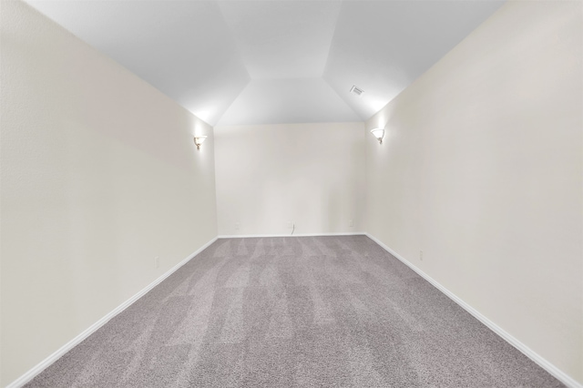 carpeted spare room with lofted ceiling