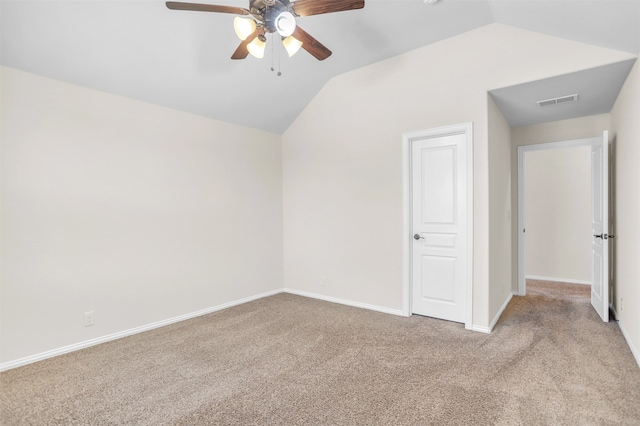 empty room featuring light carpet, vaulted ceiling, and ceiling fan