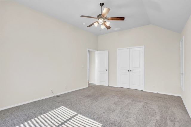 empty room with lofted ceiling, ceiling fan, and carpet