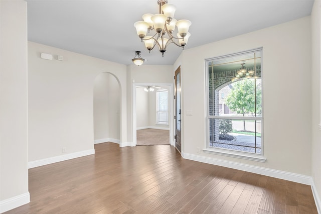 unfurnished room featuring an inviting chandelier and hardwood / wood-style flooring