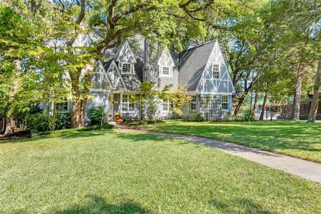 english style home featuring a front yard