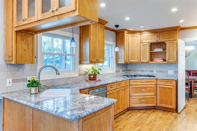 kitchen featuring light stone countertops, kitchen peninsula, and sink