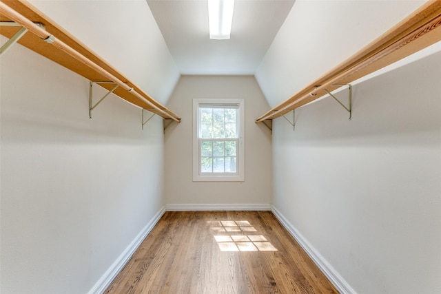 walk in closet with wood-type flooring and lofted ceiling