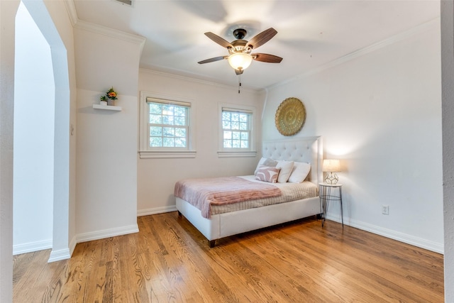 bedroom featuring ceiling fan, wood-type flooring, and ornamental molding