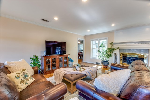 living room with wood-type flooring, crown molding, and a premium fireplace