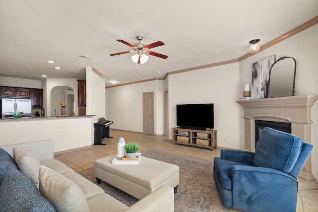 living room featuring light tile patterned flooring, ornamental molding, and ceiling fan