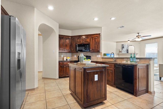 kitchen featuring a kitchen island, sink, light tile patterned floors, and black appliances