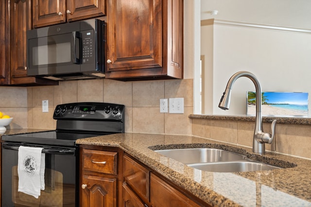 kitchen with decorative backsplash, black appliances, sink, and light stone counters