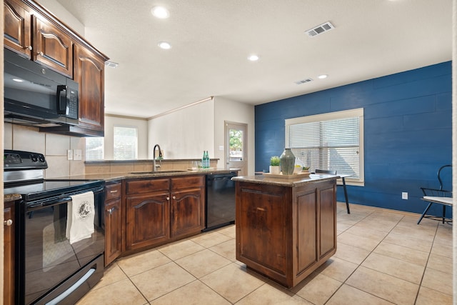 kitchen with light tile patterned floors, a kitchen island, sink, and black appliances