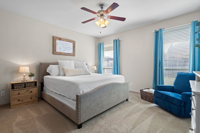 carpeted bedroom with ceiling fan and multiple windows