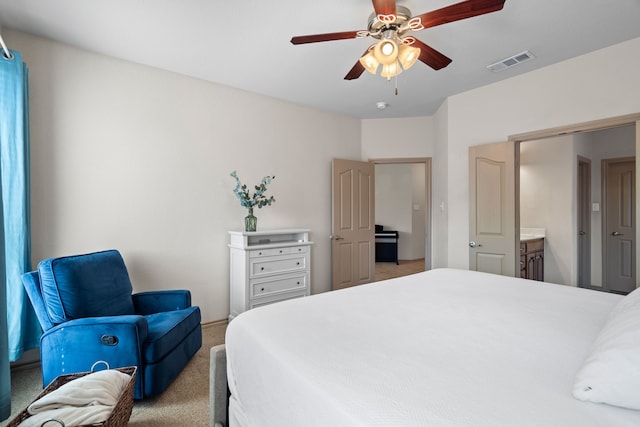 bedroom with light carpet, ensuite bath, and ceiling fan