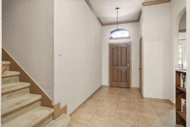 entrance foyer featuring light tile patterned floors and ornamental molding