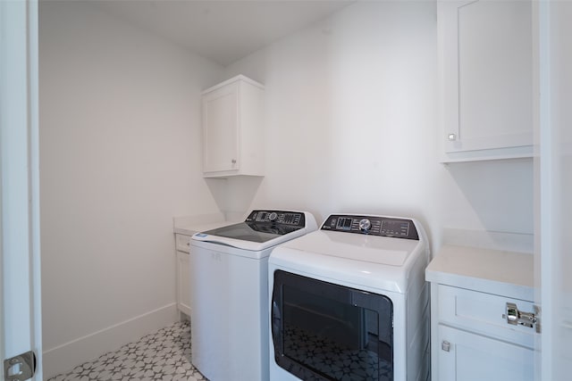 clothes washing area with washer and clothes dryer and cabinets