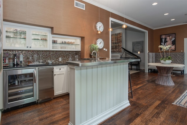 kitchen featuring dark hardwood / wood-style floors, white cabinets, stainless steel refrigerator, wine cooler, and decorative light fixtures