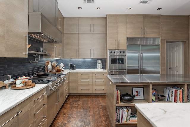 kitchen featuring stainless steel appliances, dark wood-type flooring, wall chimney range hood, and tasteful backsplash