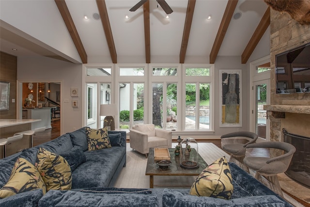 living room with beamed ceiling, ceiling fan, a fireplace, high vaulted ceiling, and hardwood / wood-style flooring