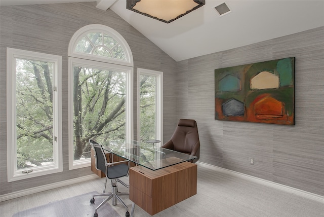 home office featuring lofted ceiling, plenty of natural light, and light colored carpet