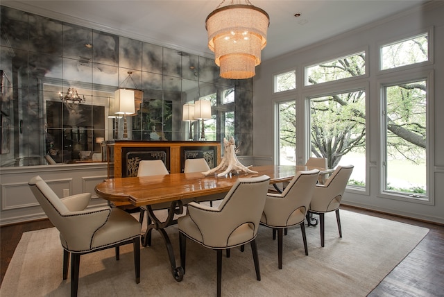 dining area with ornamental molding, hardwood / wood-style floors, and a chandelier