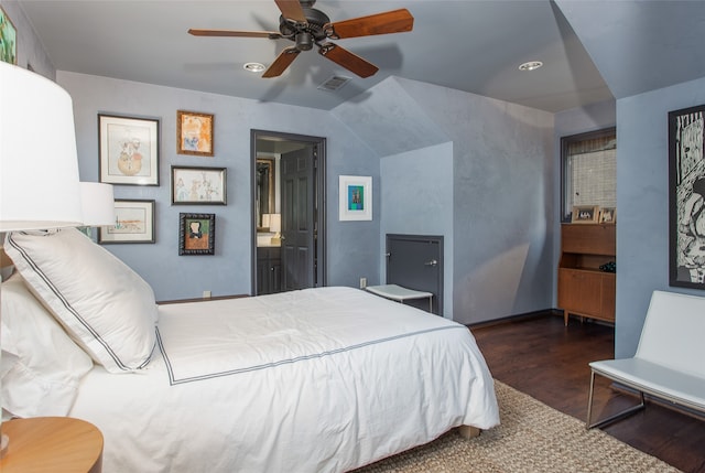 bedroom featuring ceiling fan, lofted ceiling, connected bathroom, and dark wood-type flooring