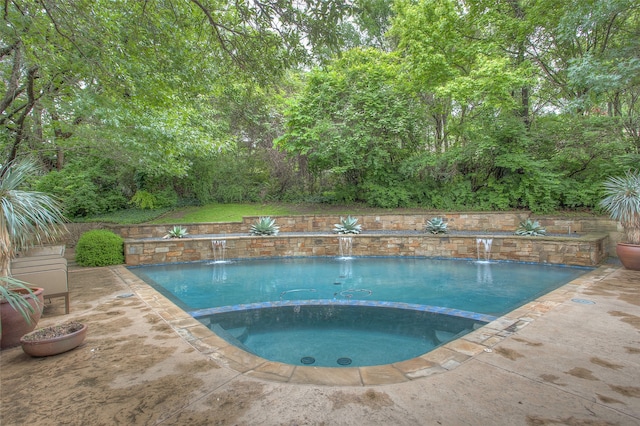 view of pool with an in ground hot tub, a patio, and pool water feature