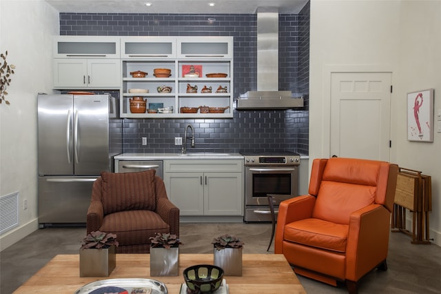 interior space featuring tasteful backsplash, wall chimney exhaust hood, sink, white cabinetry, and appliances with stainless steel finishes