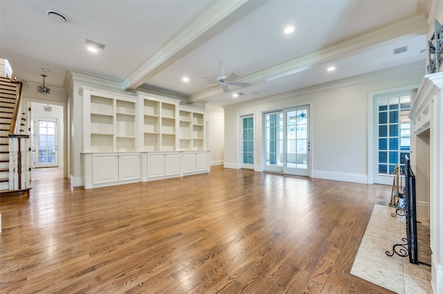 unfurnished living room featuring ceiling fan, beam ceiling, a high end fireplace, hardwood / wood-style flooring, and crown molding