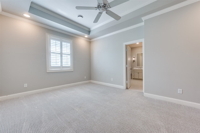 unfurnished room featuring light carpet, a tray ceiling, crown molding, and ceiling fan