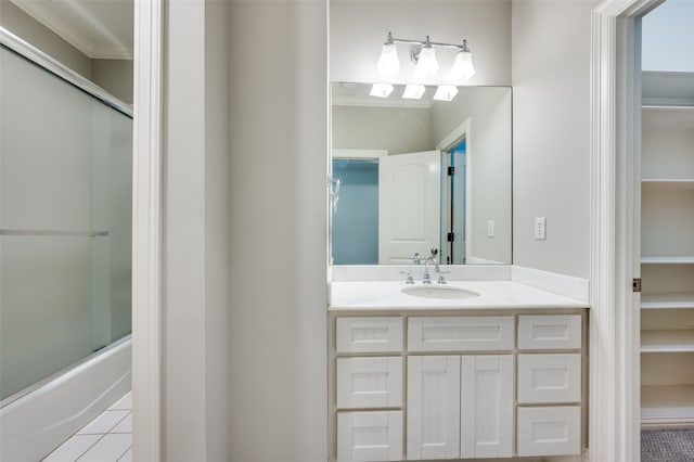 bathroom featuring tile patterned flooring, shower / bath combination with glass door, and vanity