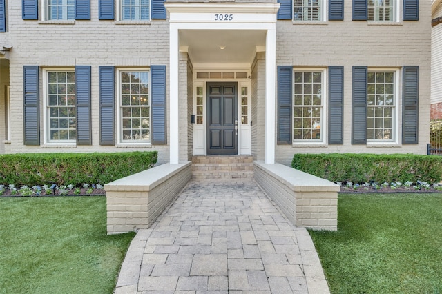 entrance to property with a lawn