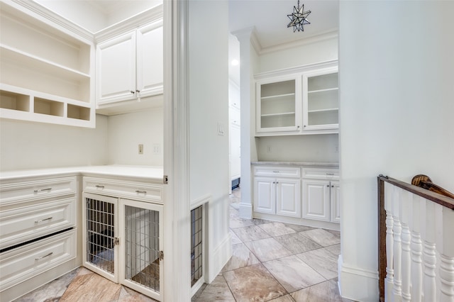 interior space with crown molding and white cabinets