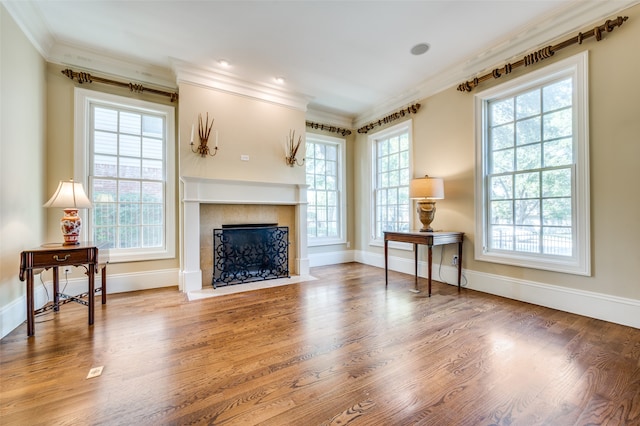 living room with crown molding, plenty of natural light, and hardwood / wood-style floors