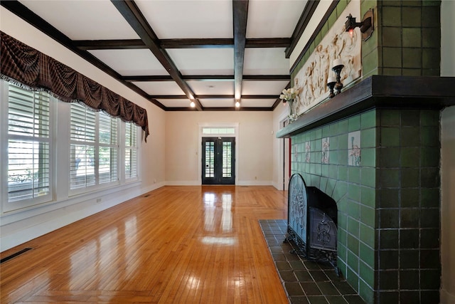 unfurnished living room featuring beam ceiling, french doors, wood finished floors, coffered ceiling, and baseboards