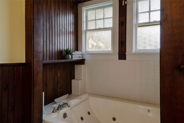 bathroom with tile patterned floors, tiled bath, ceiling fan, and plenty of natural light