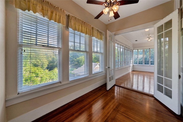 unfurnished sunroom with ceiling fan