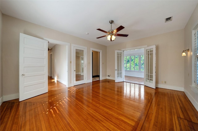 spare room featuring french doors, wood finished floors, visible vents, and baseboards