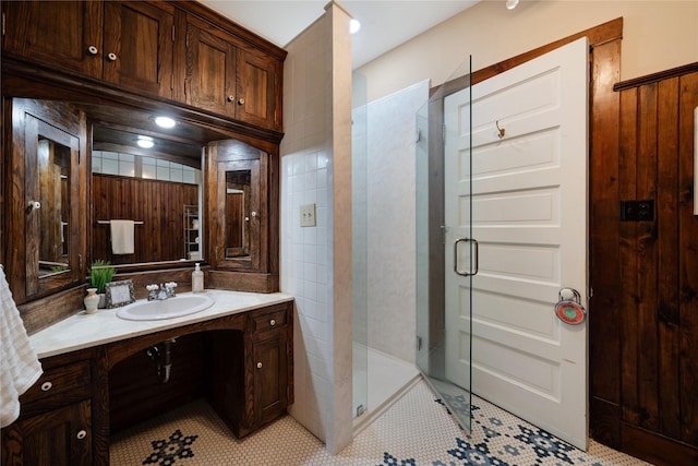 bathroom with tile patterned flooring, a shower stall, and vanity