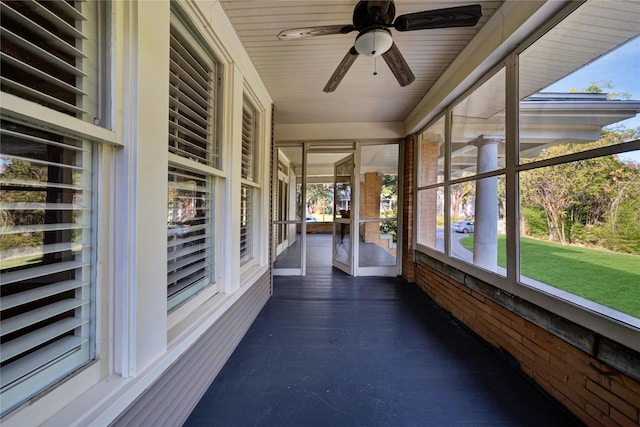 unfurnished sunroom featuring a ceiling fan