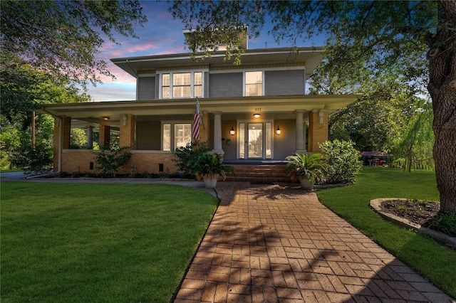 view of front facade with covered porch and a yard